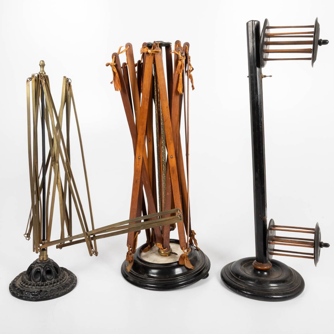 Group of Swifts and Yarn Winder: Group of Swifts and Yarn Winder, 19th Century, Comprising: An ebonized wood squirrel cage winder, a swift with a brass center column on an ebonized and marble base and a swift with cast iron base