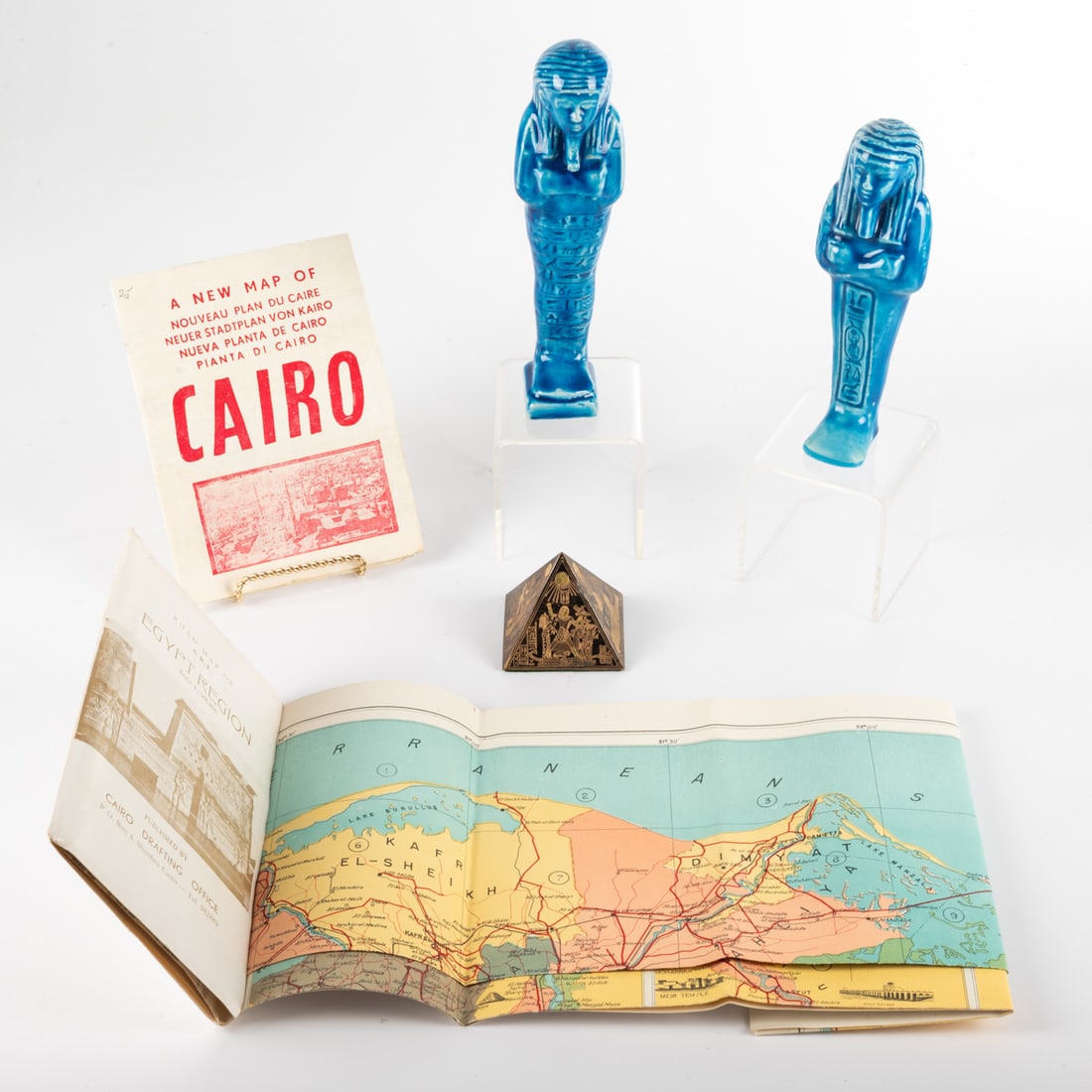 Egyptian Decorative Items: Egyptian Decorative Items, 20th Century Consisting of two Ushabti blue faience figurines, two booklets and a small pyramid. Dims.: H: 8 x 2 1/4 x D: 2 in. approx. From the Estate of John A.