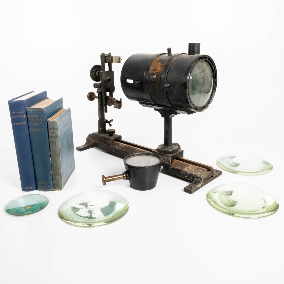 Lenses and Books on Lenses.: Set of 4 condensing lenses, an optical lens, spectroscopy lens holder, and 3 books on lenses and prisms. 19th and 20th century. 3 lenses are 6 in. diameter. Biconvex lens is 19th century aqua-glass,