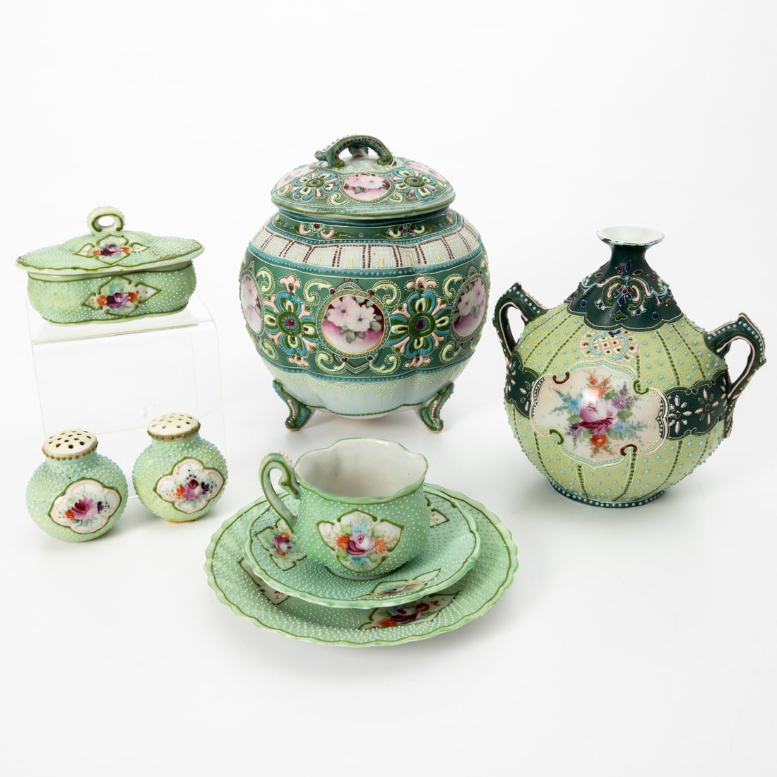 Eight Japanese Moriage Decorative Items: Eight Japanese Nippon Moriage Porcelain Decorative Items, Late Meiji Period. Comprising a biscuit jar, two salt and pepper shakers, a vase, a tea cup, a covered box and two small plates Biscuit Jar,