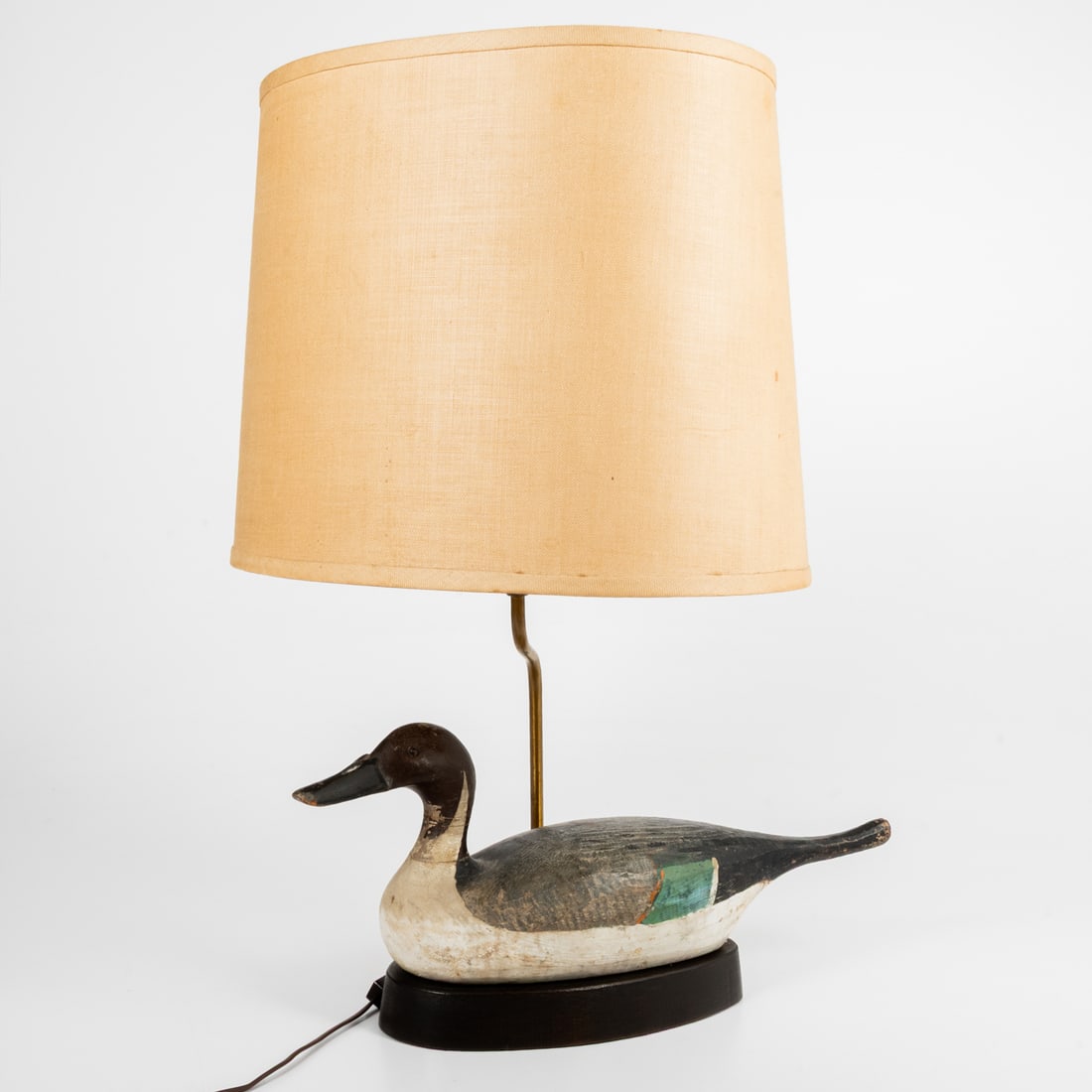 A Duck Decoy Lamp: A Carved Wood and Painted Duck Decoy, Mounted as a Lamp, 20th Century. Lamp without shade, H: 12 1/2 x L: 17 3/4 x W: 5 3/4 in.