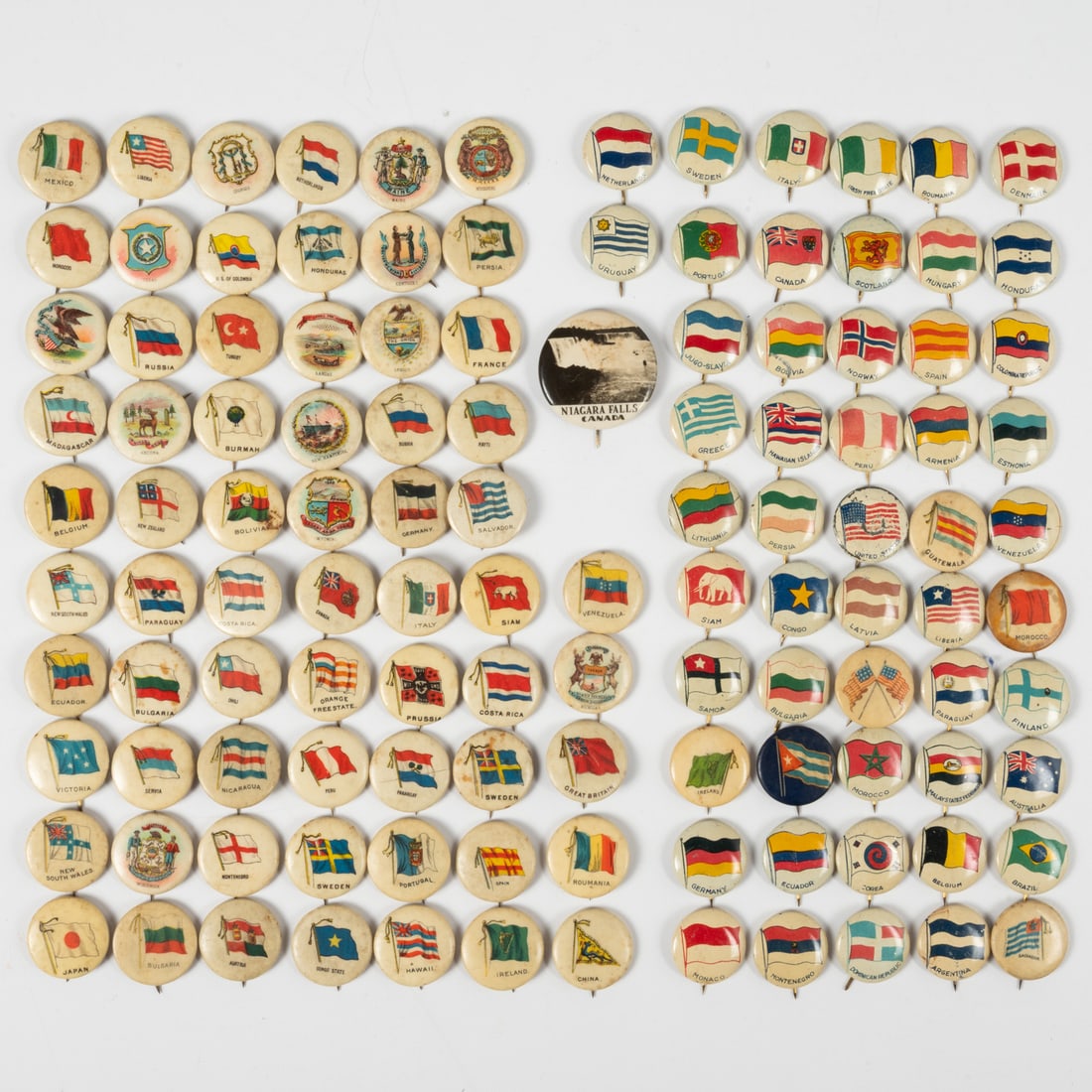 100 Piece Country Pinback Collection: One Hundred Piece Collection of Country Themed Pinbacks, 20th Century, Together with thirteen U.S. States, two flags, and three defunct-state pinbacks. Largest Pinback, Dia: 7/8 in.