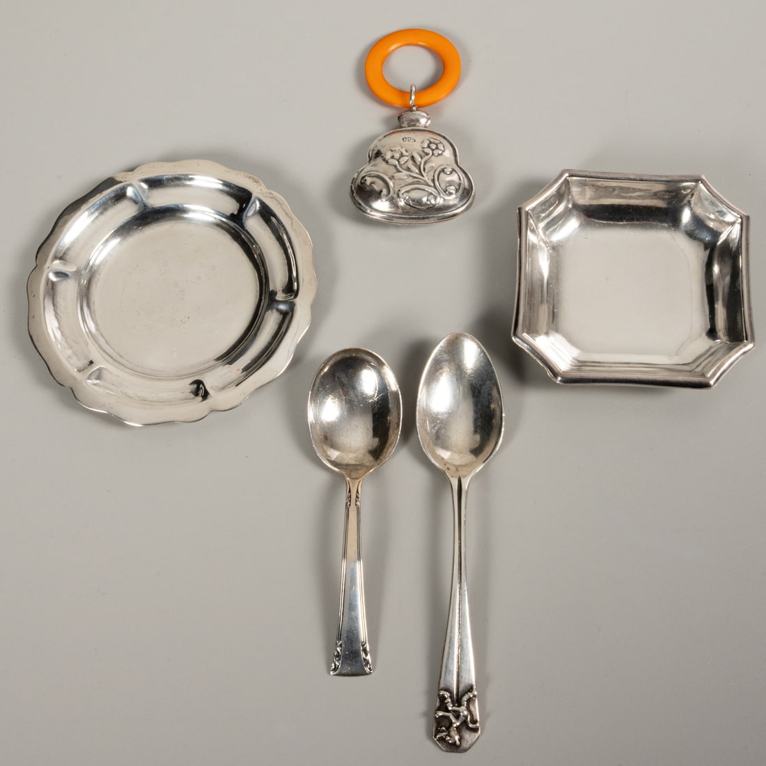 Five Sterling Silver Serving Items: Five Sterling Silver Serving Items for Infants, 20th Century, Comprising a baby rattle, two spoons and two small plates. Each marked with Sterling and 925. Total Approx. Weight for Weighable Silver, 4