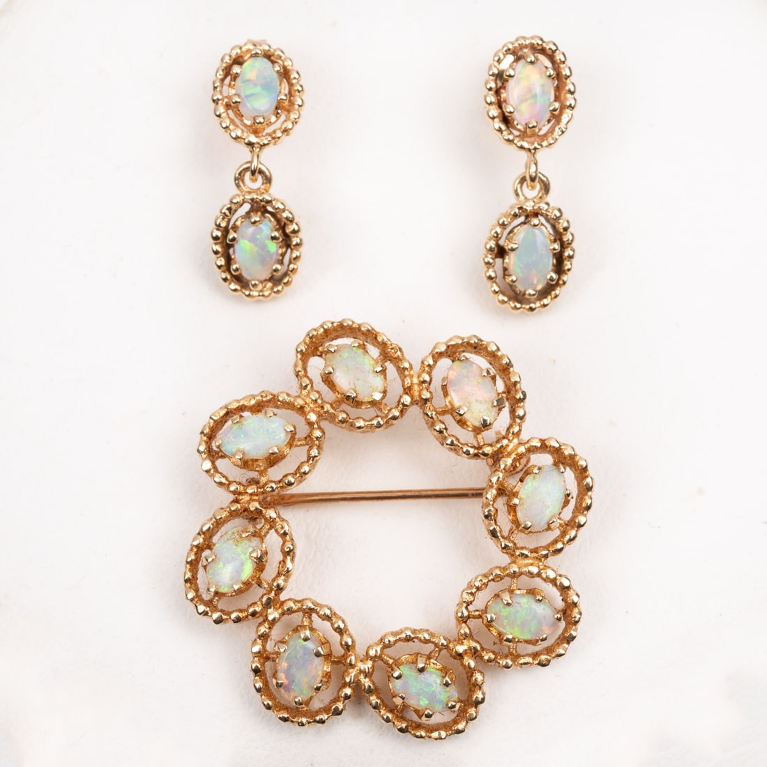 A 14kt Yellow Gold and Opal Brooch and Earrings Se: A 14kt Yellow Gold and Opal Brooch and Earrings Set, The brooch set with 8 cabochon cut natural opal stones, approx. 0.25 pts each, the earrings set with two cabochon cut natural opal stones approx.