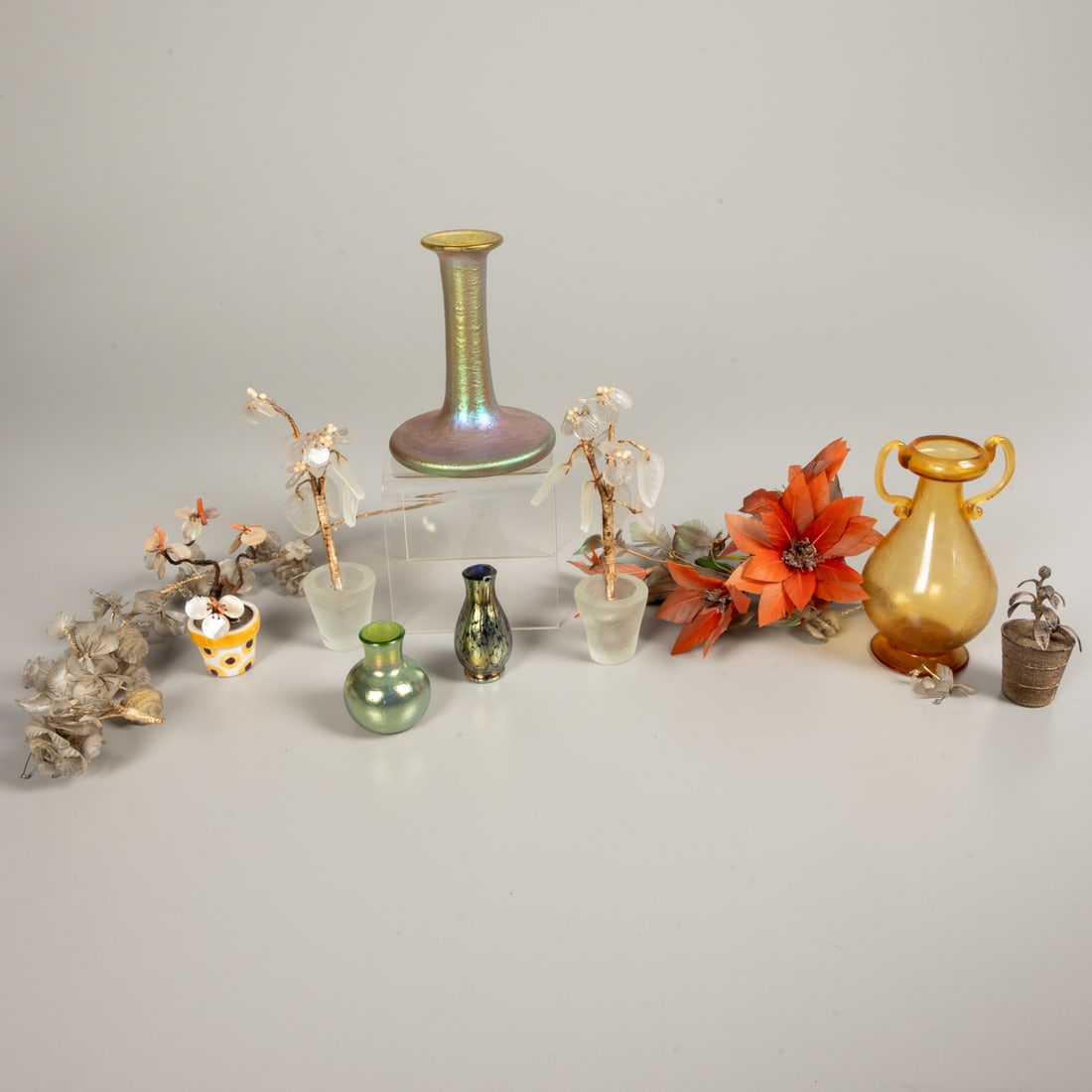 Group of Glass Decorative Objects: A Group of Iridescent and Frosted Glass Decorative Objects, Together with a handcrafted feather flower posy and an indigenous folk art fish scale floral and vine bough. Glass unsigned. Tallest vase,