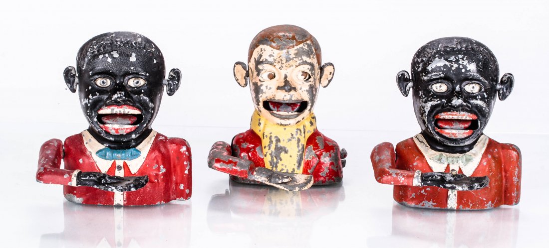 A Pair of Aluminum Jolly N (Starkie/Sonny Boy Small: A Pair of Aluminum Jolly N (Starkie/Sonny Boy Small with Movable Ears) Mechanical Banks Manufactured by Thomas Ashworth, ca. 1945, Place a coin in the hand and press the lever on the back of the bank.