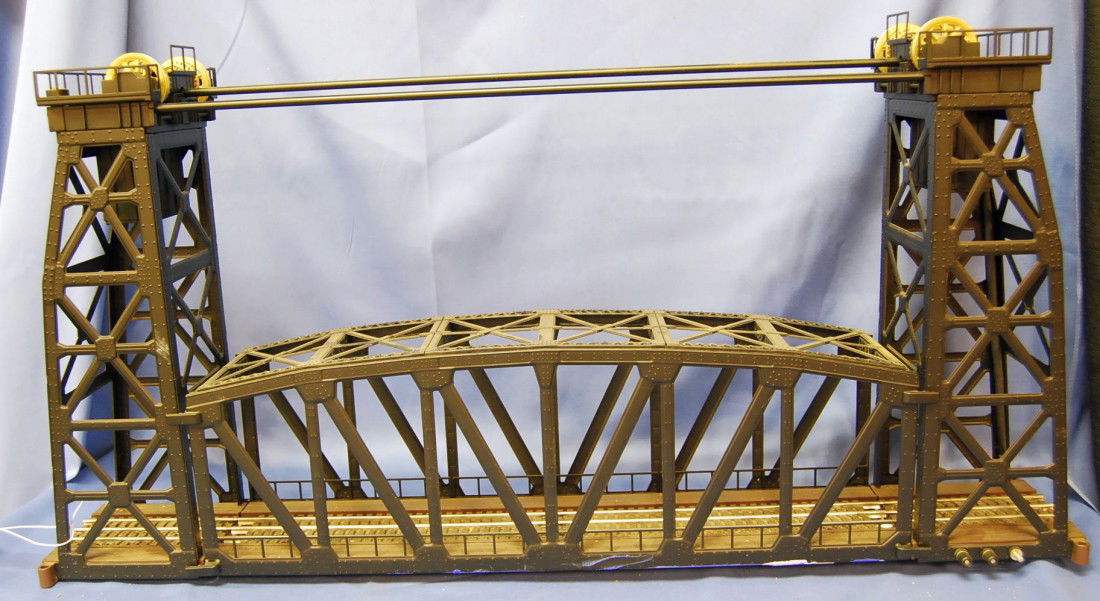 LIONEL DOUBLE TOWER DRAWBRIDGE: METAL FRAME AND GEARS, ALL IN GOOD SHAPE. 30 INCHES LONG, 15 INCHES TALL AND 5.25 INCHES WIDE.