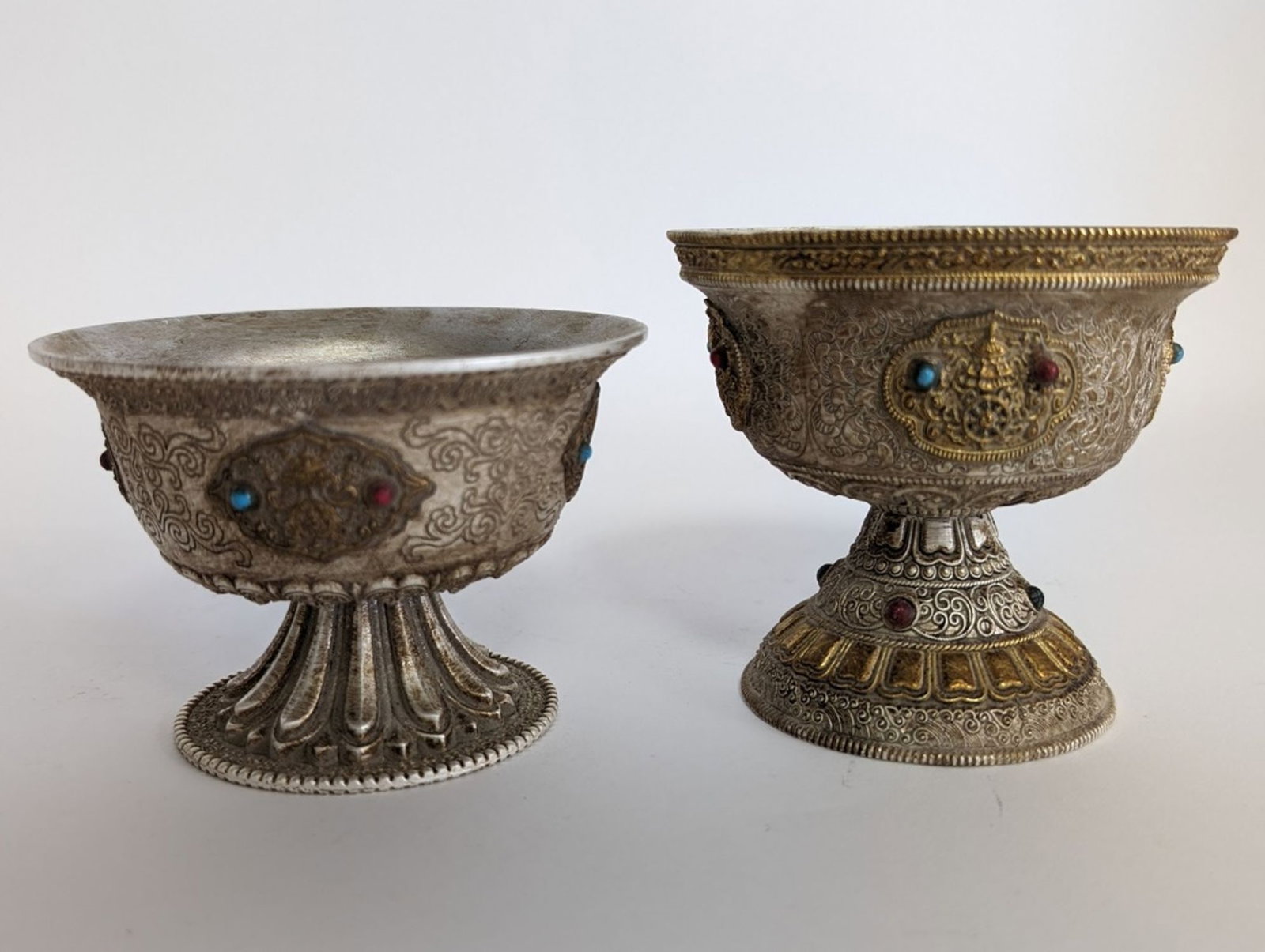 2 Antique Buddhist Ritual Cups: Fine early 20th century Buddhist Ritual cups. Finely crafted. Truly beautiful pieces. One cup measures 3.5H x 4W in. Second cup: 2.75H x 4.25W in. Good condition showing aging and minor wear. Please b
