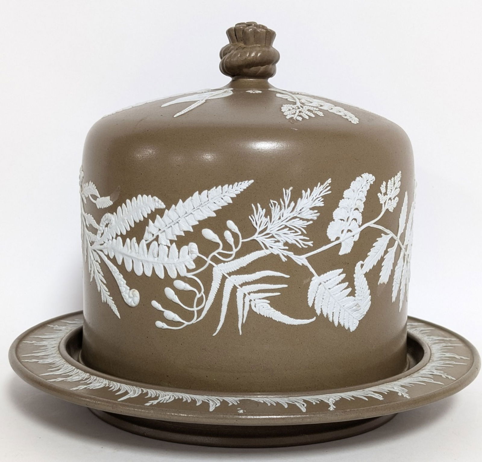 Antique Jasperware Cake or Cheese Dome 10H x 12W ": Fine antique brown jasperware cheese dome and stand, possibly by Dudson or attributed to Adams Tunstall, featuring white applied decoration of ferns and a rope finial. 10H x 12W in. Very good conditio