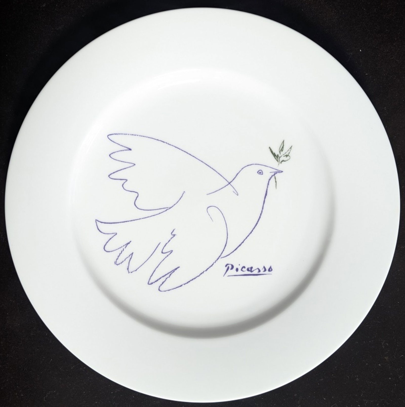 Picasso Porcelain "Dove of Peace" Plate: Timeless porcelain plate featuring Pablo Picasso's iconic Dove of Peace artwork. The design is a minimalist blue outline of a dove carrying an olive branch. It is inspired by the original 1949 lithogr