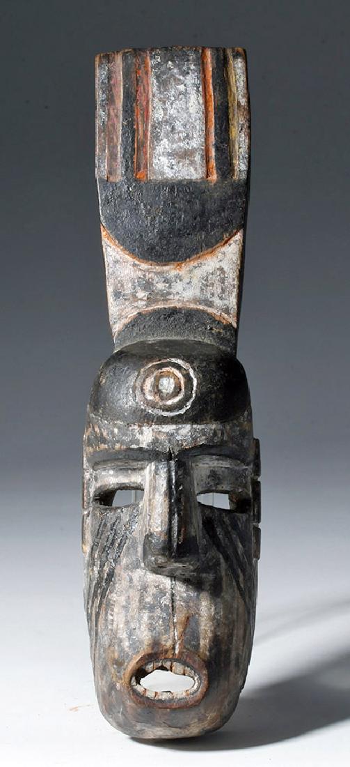 20th C. African Igbo Painted Wood MBA Mask: Africa, Nigeria, Igbo people, early 20th century CE. This is a wood mask with a human face and a tall, flat crest, all painted in shades of red, white, and black. The face has exaggerated nose and ope
