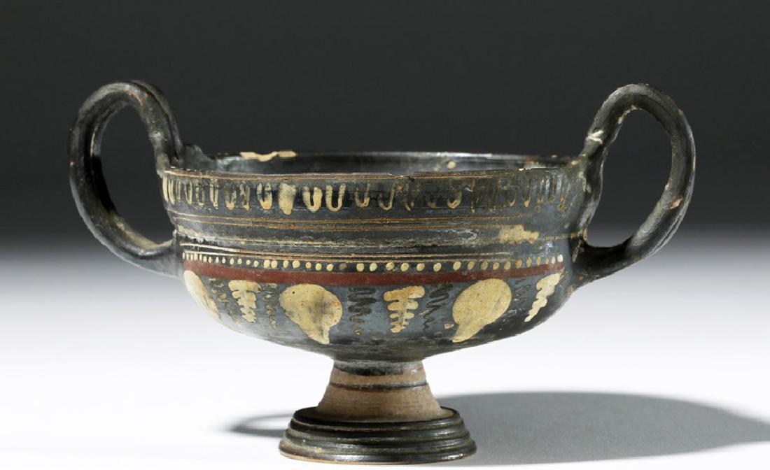 Greek Gnathian Polychrome Kylix w/ Grapes: Southern Italy, Apulia, Gnathian Teano Ware, ca. 360 to 320 BCE. This is a beautiful kylix, a drinking cup, with two raised handles extending from near the rim and a pronounced foot. The black backgro