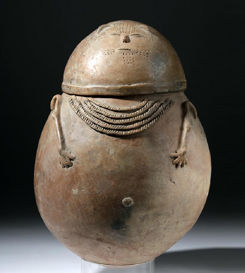 Chimila Pottery Anthropomorphic Burial Urn Egg-Shaped: Pre-Columbian, Colombia, between Magdalena & Cesar, Chimila, ca. 1000 to 1500 CE. A hand-built terracotta burial urn with an egg-shaped body characteristic of the Chimila style. The lid/head presents 