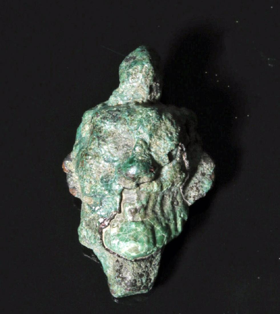 Neo Assyrian Bronze Pazuzu Amulet: Ancient Near East, Neo-Assyrian period, ca. 800 to 600 BCE. A cast bronze head with a ring for suspension at the top. The head has the grotesque features of Pazuzu, the king of the demons of the wind 