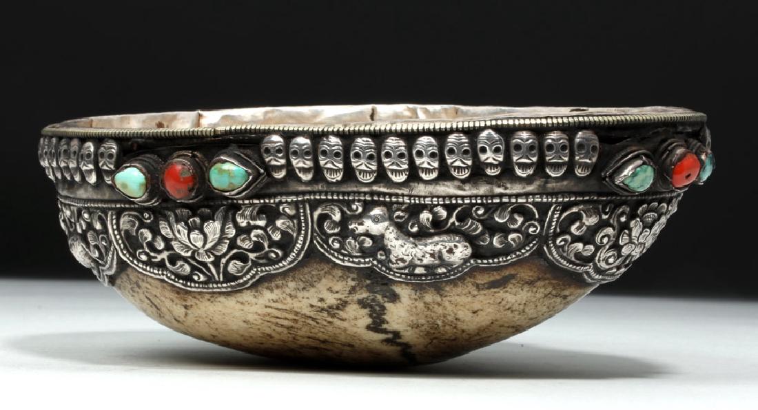 19th C. Tibet Silver & Stone Kapala (Skull): Central Asia, Tibet, ca. 19th century CE. A fine silver-lined example of a kapala, made from the top of a human skull, ringed with repousse symbols of deer and flowers. On each of the four sides are t