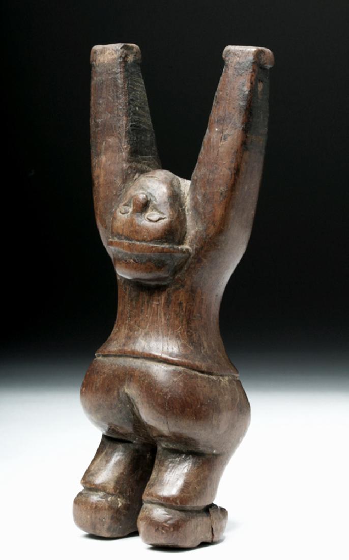 Very Fine Guatemalan Wooden Slingshot / Ondilla: Central America, Guatemala, early 20th century CE. A wooden slingshot, hand-carved in the form of an acrobatic male figure either doing a handstand or swinging from his hands. The man is dressed in a 