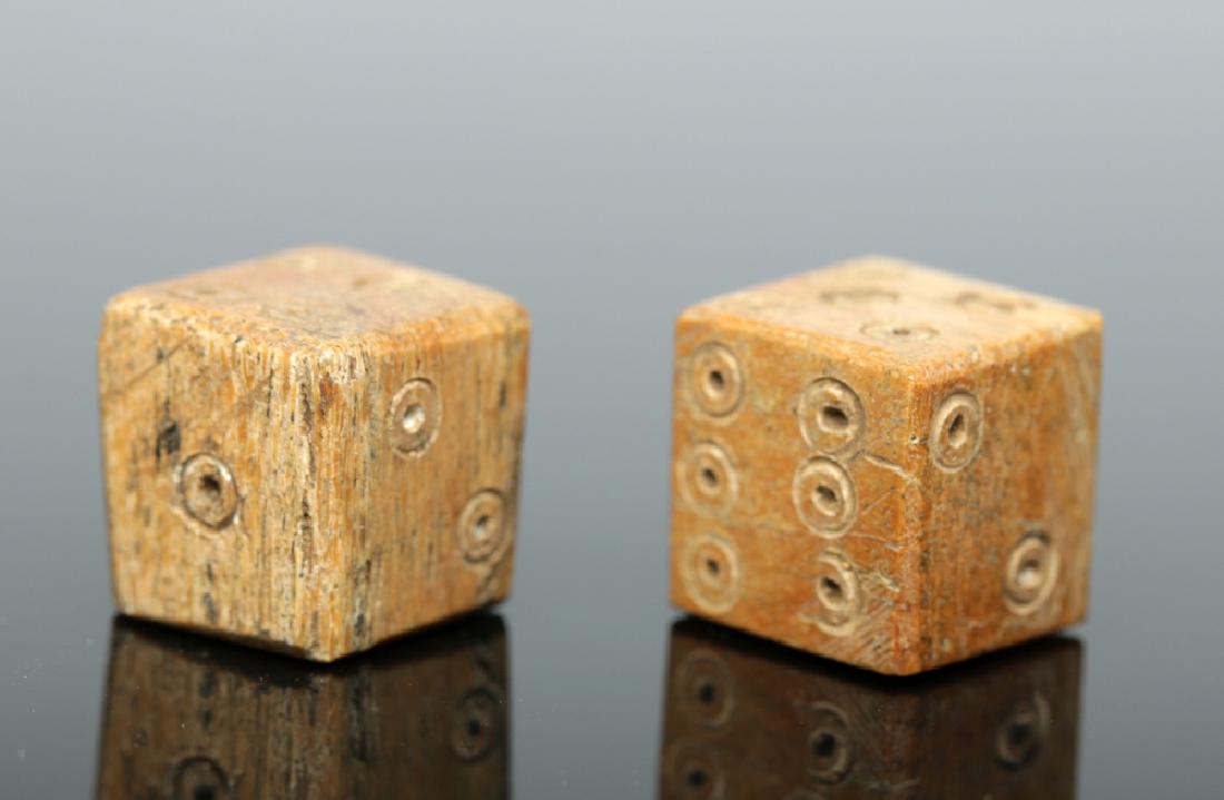 Near Choice Pair of Roman Bone Dice: Roman, Imperial Period, ca. 1st to 3rd century CE. Two charming, six-sided gaming dice made from bone, probably of a cow or other type of livestock. Each face is inscribed with concentric circles to f