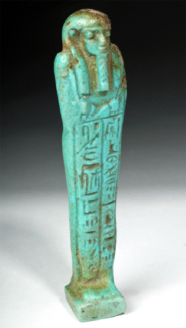 Egyptian Late Period Faience Ushabti: **First Time At Auction** Egypt, Late Dynastic Period, 26th Dynasty, ca. 664 to 525 BCE. A Late Period ushabti (shabti) painted with a turquoise faience that turns pale brown along the figure's back,