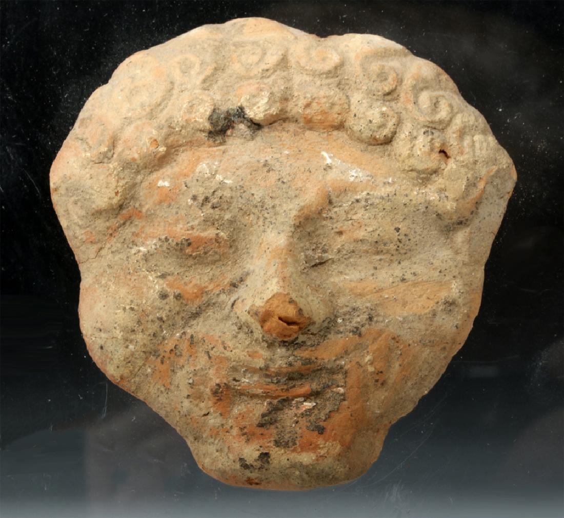 Greek Earthenware Gorgoneion Applique: **First Time At Auction** Ancient Greece, ca. 5th to 4th century BCE. A mold-made earthenware maskette depicting the head of a Gorgon - a frightening beast-like female creature seen as early as the da