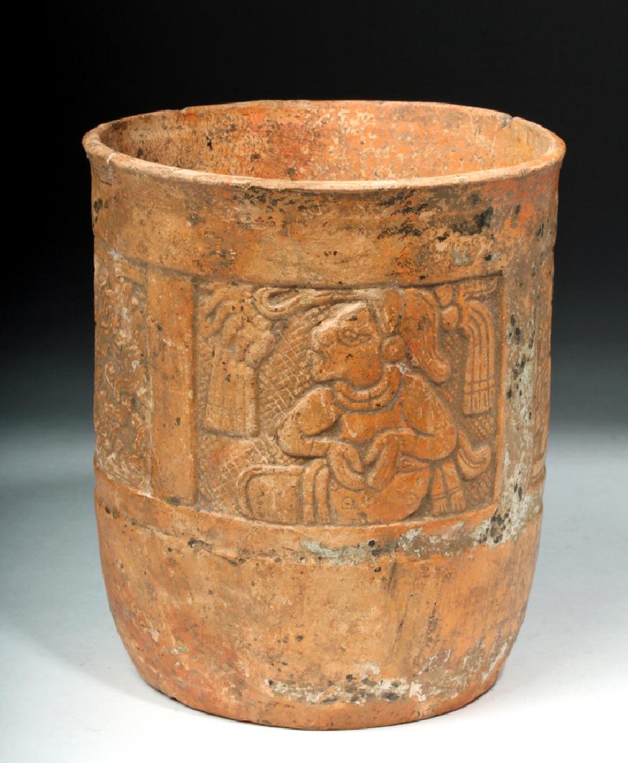 Mayan Redware Cylinder with 4 Molded Panels: Pre-Columbian, Mayan Territories, Honduras, ca. 550 to 900 CE. A finely executed Mayan redware cylinder featuring four square panels skillfully molded in relief. Two of these panels present a seated l