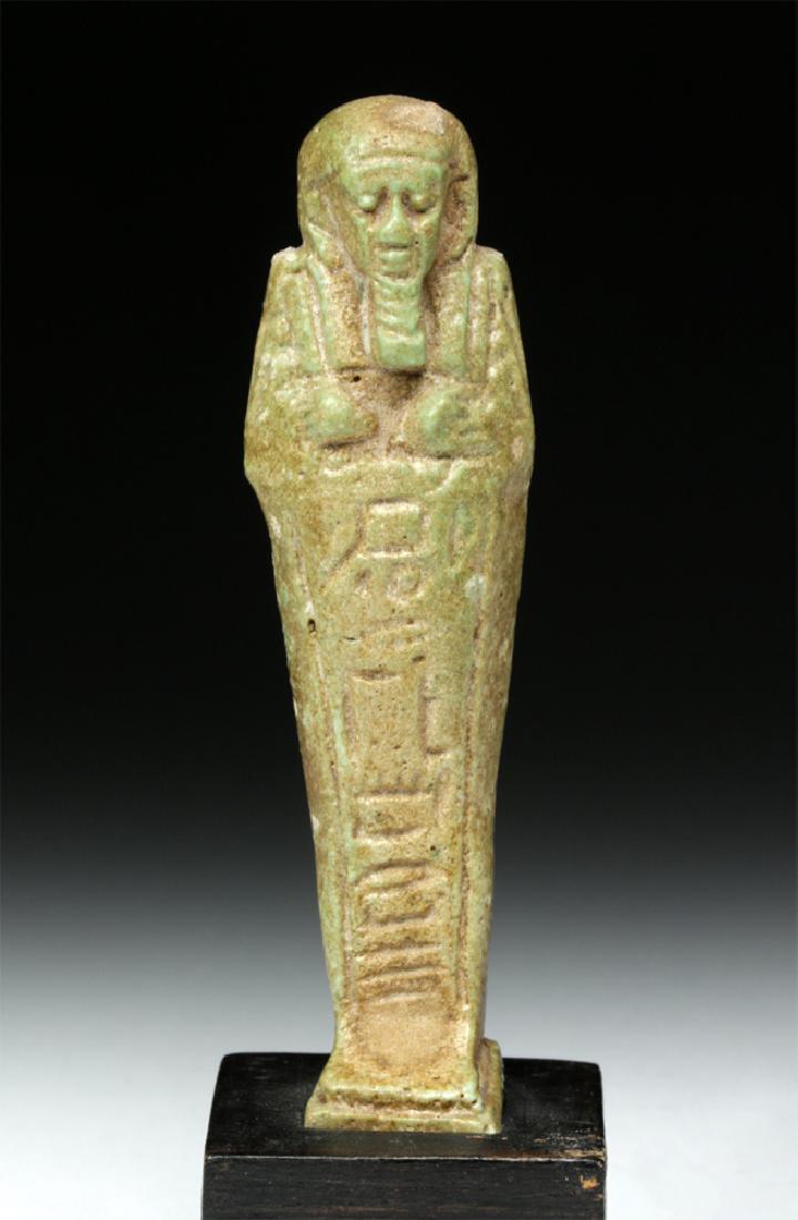 Egyptian Late Period Green Faience Ushabti: Egypt, Late Dynastic Period, 26th to 31st Dynasty, ca. 664 to 332 BCE. A faience ushabti (or shabti), standing in mummiform, with a tripartite wig, a braided false beard, and clearly visible facial fe