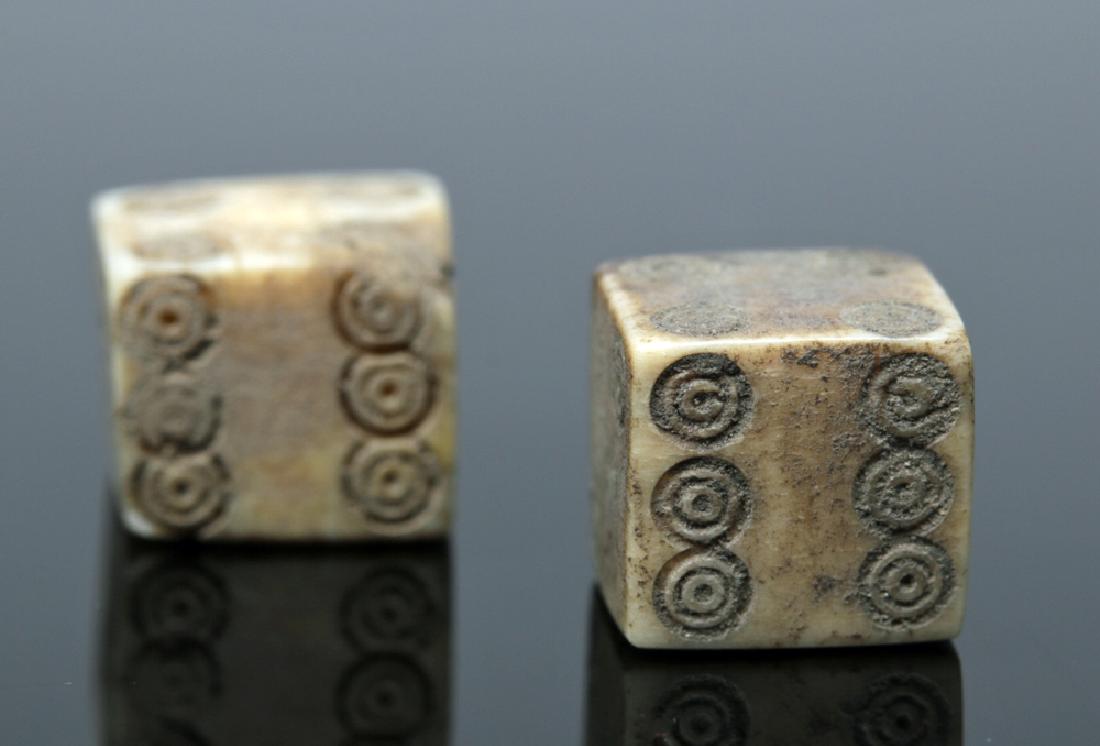 Pair of Roman Bone Gaming Dice: Roman Empire, Imperial Period, ca. 1st to 4th century CE. An excellent and functional set of six-sided dice, carved from ancient bovine bone of white and grey hues, with each die displaying one throug