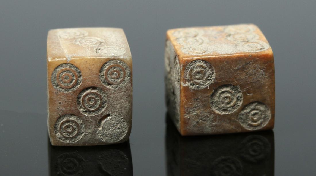 Pair of Roman Bone Dice: Roman Empire, Imperial Period, ca. 1st to 4th century CE. An excellent and functional set of six-sided dice, carved from ancient bovine bone of grey and russet hues, with each die displaying one throu