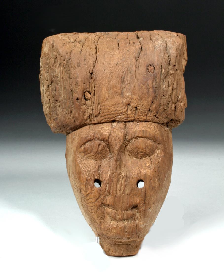 Egyptian 25th Dynasty Wood Sarcophagus Mask: Egypt, Late Period, 25th Dynasty, ca. 664 to 332 BCE. A wood carved mask with large eyes, a thin nose, and a small mouth. The figure has been carved with a large, rounded headdress that sits low acros
