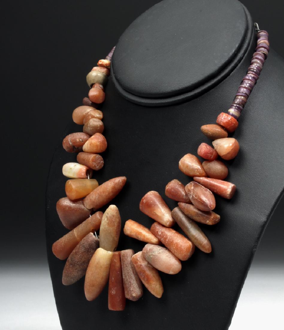 Tairona Rock Crystal / Carnelian Beaded Strand: **Originally Listed At $600** Pre-Columbian, Colombia, Tairona, ca. 1000 to 1300 CE. A lovely necklace comprised of many hand-cut disc-shaped shell beads of purple and wine hues around the neck with n
