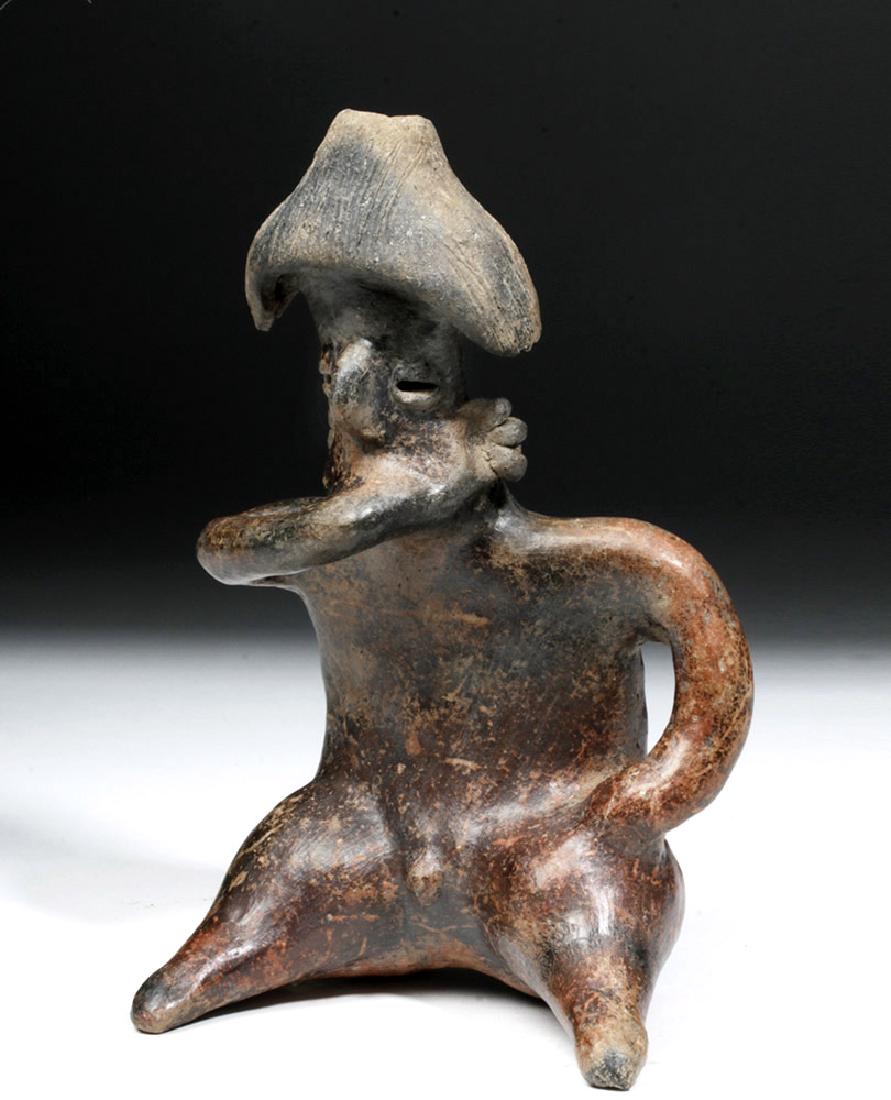 Jalisco Redware Seated Figure - Hunchback Male: Pre-Columbian, West Mexico, Jalisco, ca. 300 BCE to 300 CE. A hand-built redware pottery seated figure, nude save his mushroom-shaped headdress and elaborate ear ornaments. He sits with one arm to his