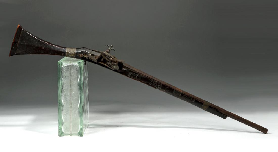 18th C. Persian Flintlock Rifle: Near East, Persia / Iran, ca. 18th century CE. A beautiful, hand-built flintlock rifle with an octagonal iron barrel slotted within a grooved wooden forestock and held in place by a thin sheet of hamm
