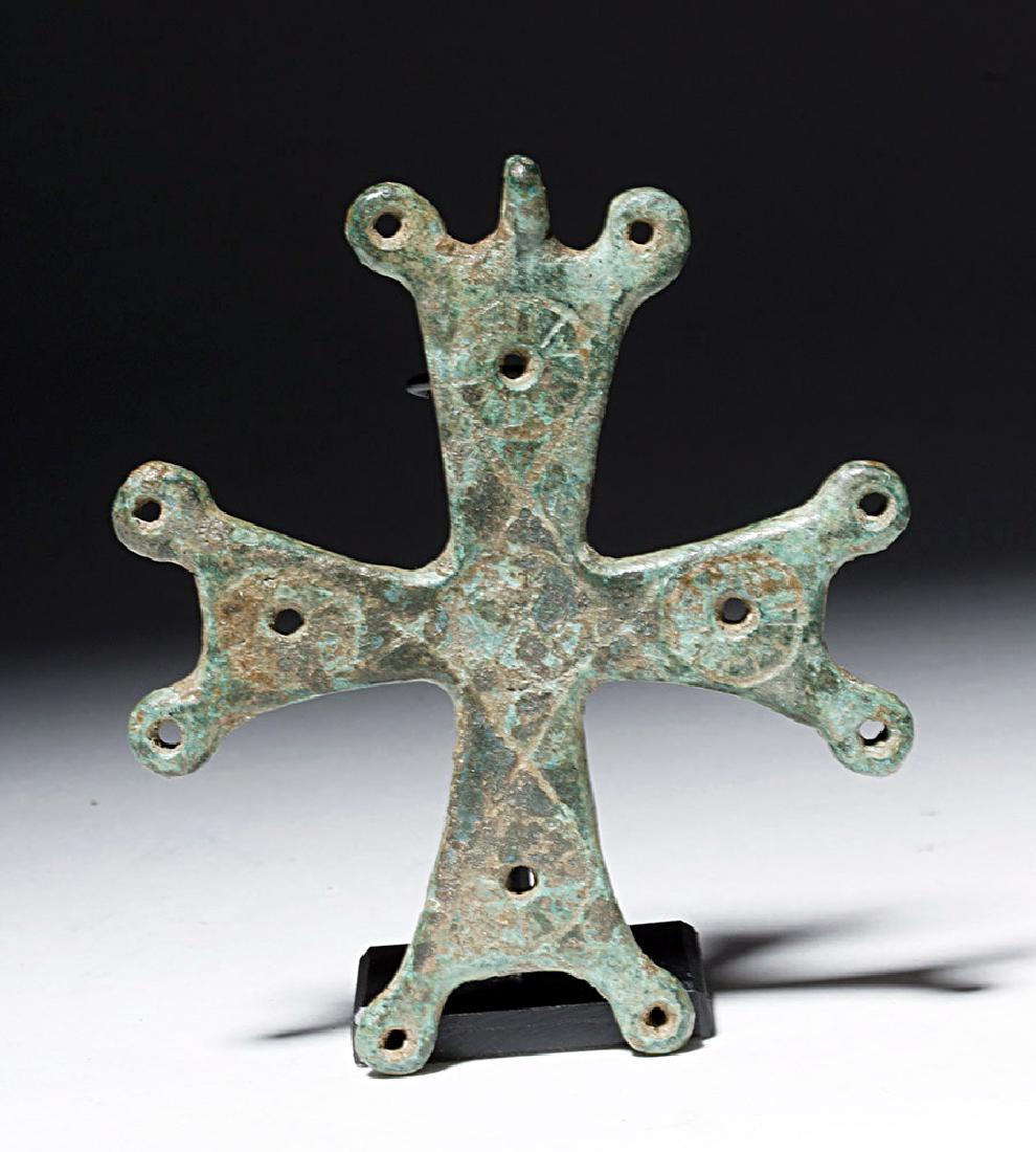10th C. Byzantine Bronze Crucifix: Byzantine Empire, ca. 10th to 12th century CE. A bronze cross with legs almost as long as arms and a top loop for suspension. Incised designs in diamond and tear drop shapes on one side give it a clea
