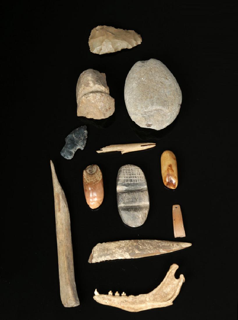 Twelve 19th C. Inuit Stone & Bone Artifacts: Arctic New World, Alaska, Alaskan Native / Inuit people, ca. 19th century CE or possibly earlier for the stone tools. A collection of twelve stone, bone, and tooth tools. The stone tools are: two hand