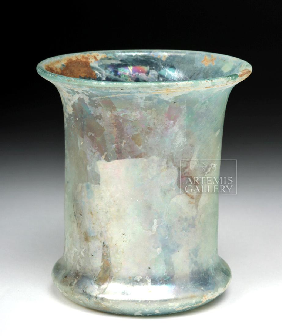 Roman Pale Green Glass Beaker: **First Time At Auction** Roman, Imperial Period, ca. 1st to 3rd century CE. A beautiful and delicate free-blown glass beaker of a pale-green hue. This vessel exhibits a slight concave base with a rou