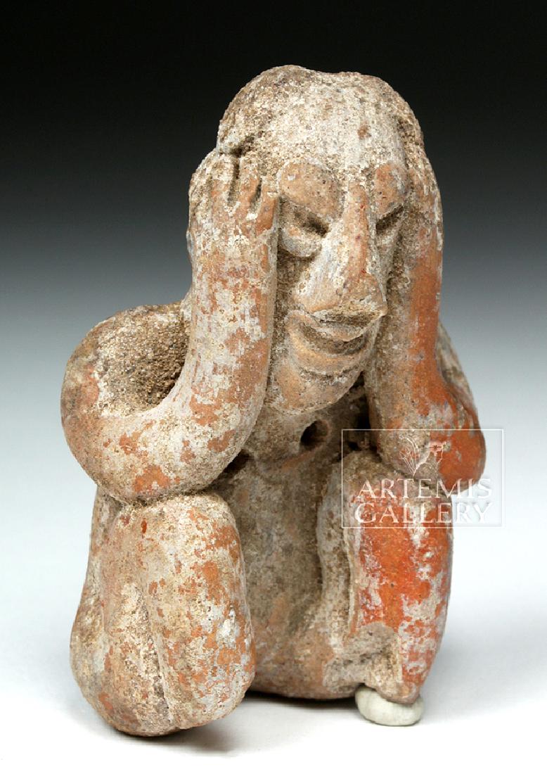 Jalisco Pottery Seated Figure - Headache Cure: **First Time At Auction** Pre-Columbian, West Mexico, Jalisco, ca. 300 BCE to 300 CE. A petite hand-built terracotta seated figure with a flat base and curled nubbin-shaped legs, a flat back, and sinu