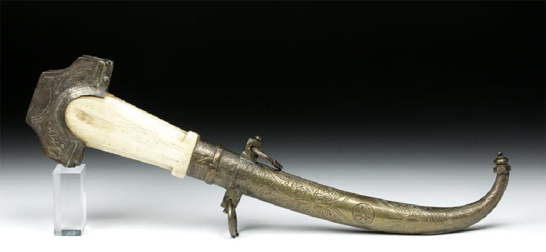 19th C Persian Steel Scimitar Bone Handle, Brass Sheath: Western Asia, Persia (present day Iran), ca. 19th century CE. A lovely steel scimitar with a slightly curved blade. The handle is made from carved bone, likely mammalian (yak or ox), with a crescent-s