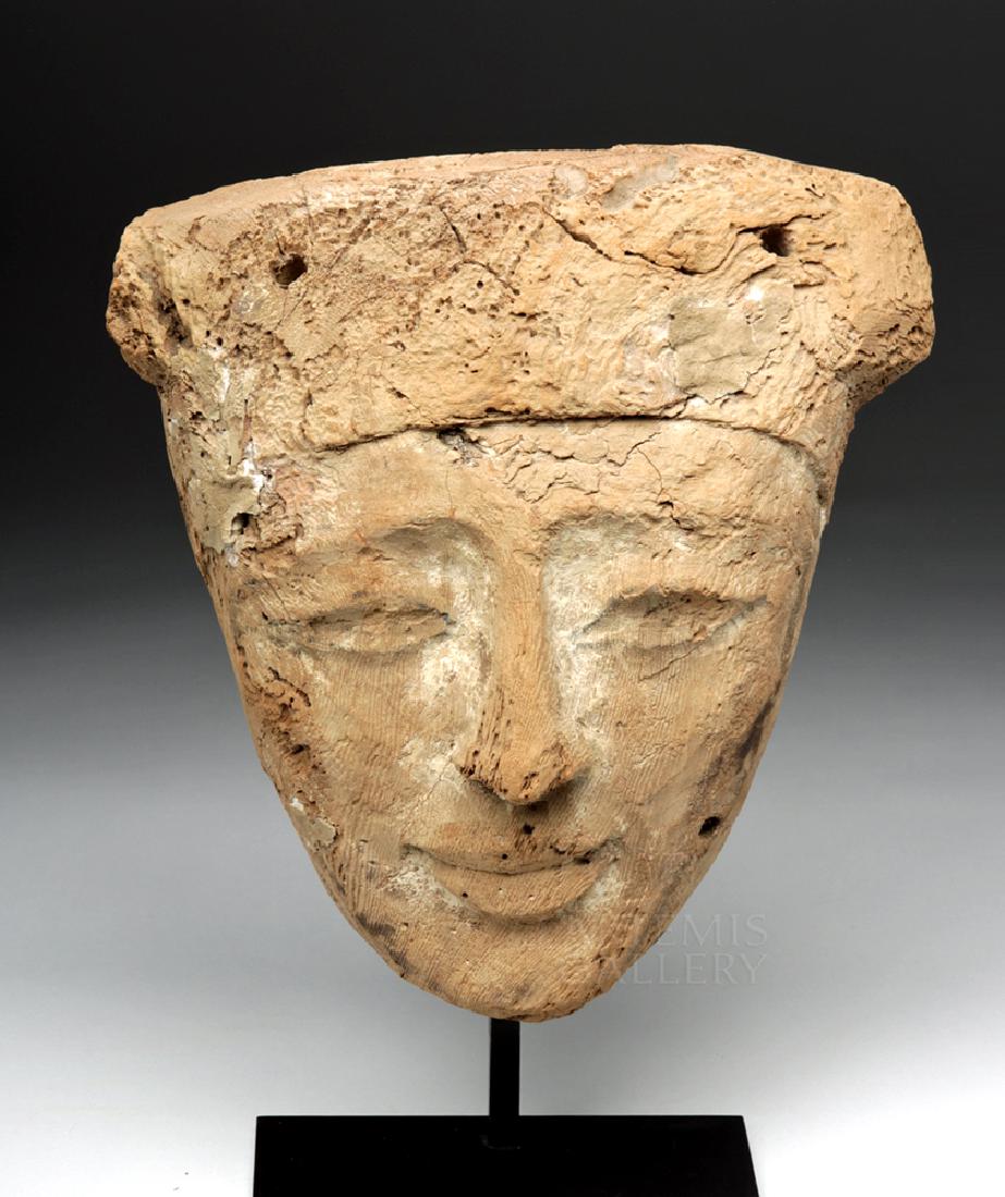 Egyptian Late Dynastic Wood Sarcophagus Mask: Ancient Egypt, Late Dynastic Period, 26th to 31st Dynasty, ca. 664 to 332 BCE. A carved wooden mask with large eyes, a slender nose, a gentle mouth with full lips, and detailed with a large, rounded h