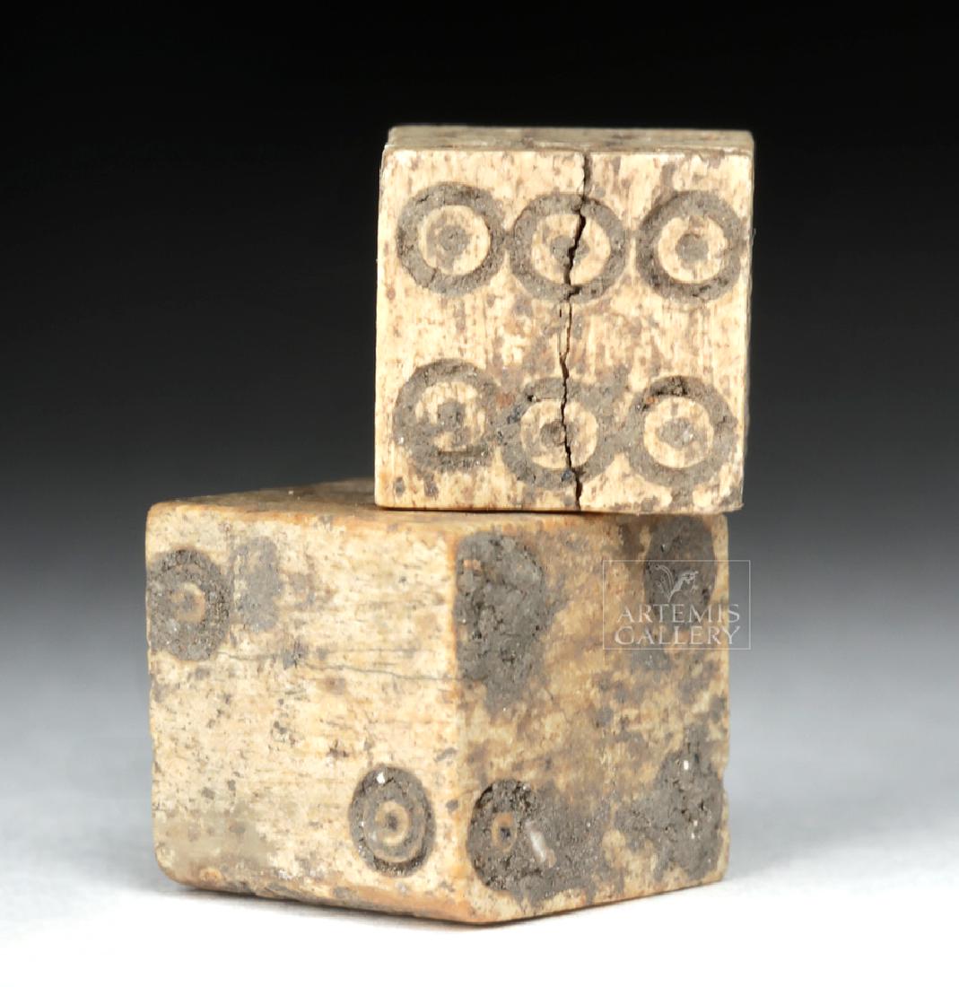 Pair of Roman Imperial Bone Dice: Roman, Imperial Period, ca. 1st to 3rd century CE. A wonderful set of gaming dice, hand-carved from the bone of a cow or another ungulate. The planar sides of each die display a series of incised conc