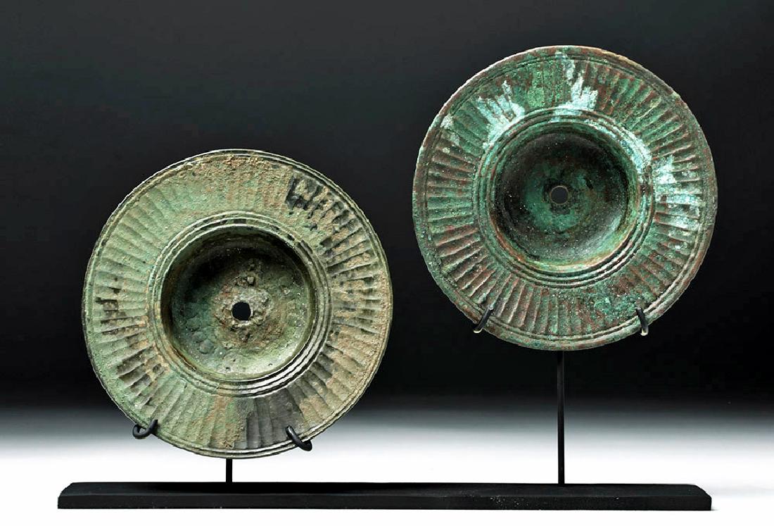 Ancient Luristan Bronze Symbols (Matched Pair): **Originally Listed At $500** Central Asia / Near East, Luristan ca. 1000 BCE. A matched pair of cast bronze cymbals, both with central depressions perforated at the center and rims decorated with a f