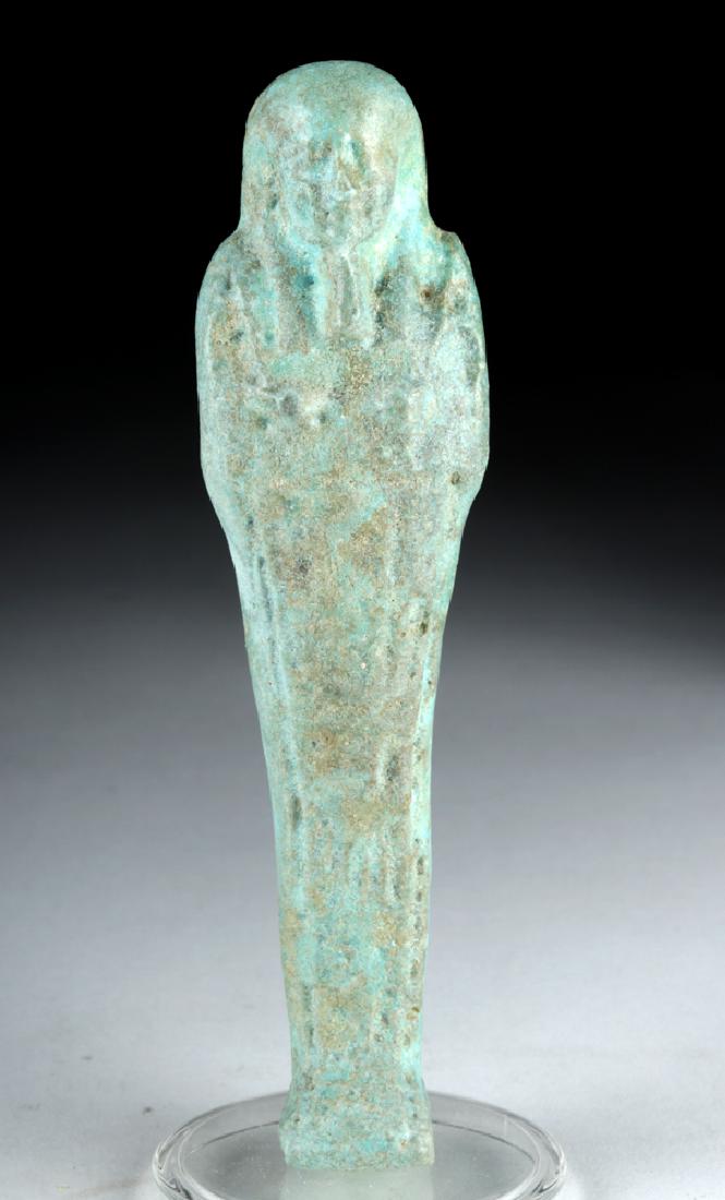 Egyptian Late Period Faience Ushabti: Egypt, Late Dynastic Period, 26th to 31st Dynasty, ca. 664 to 332 BCE. A mold-formed faience worker ushabti, of a pale blue-green color, standing in mummiform atop an integral rectangular plinth. The