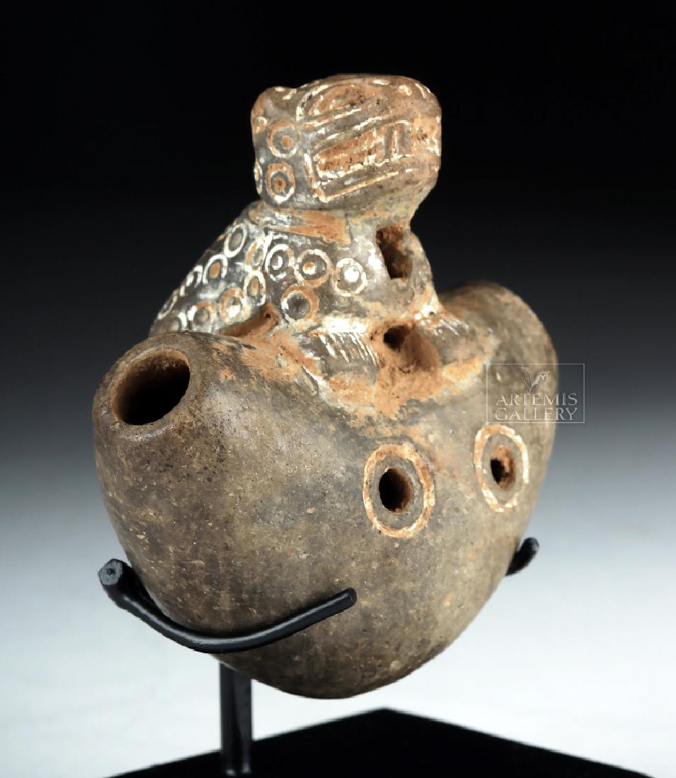 Published Tairona Pottery Jaguar Whistle: Pre-Columbian, Colombia, Tairona culture, ca. 1000 to 1550 CE. An absolutely adorable crescent-shaped whistle with a miniature jaguar perched atop it. Holes at either end of the crescent can be blown 
