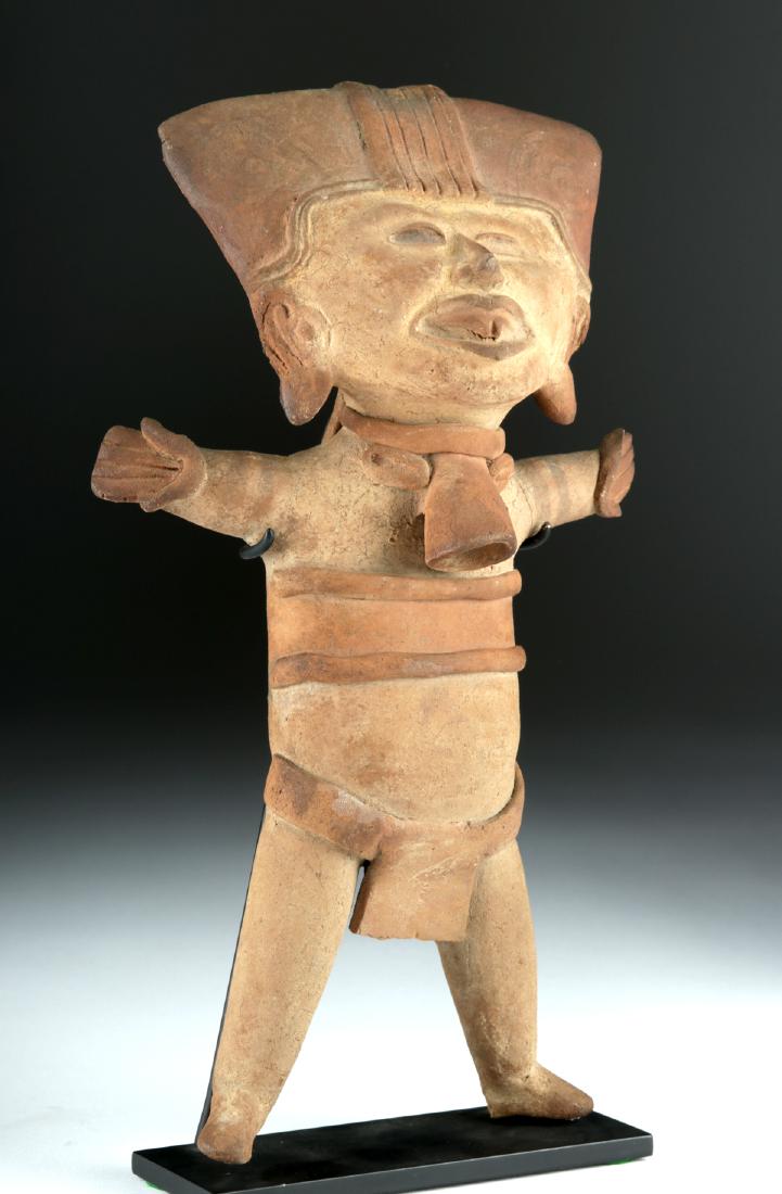 Tall Veracruz Pottery Sonriente Figural Ocarina: Pre-Columbian, Gulf Coast Mexico, Vera Cruz, ca. 3rd to 7th century CE. A ceramic standing "sonriente" figure. Like many hollow pieces of pottery from this region, it functions as an ocarina, with a m
