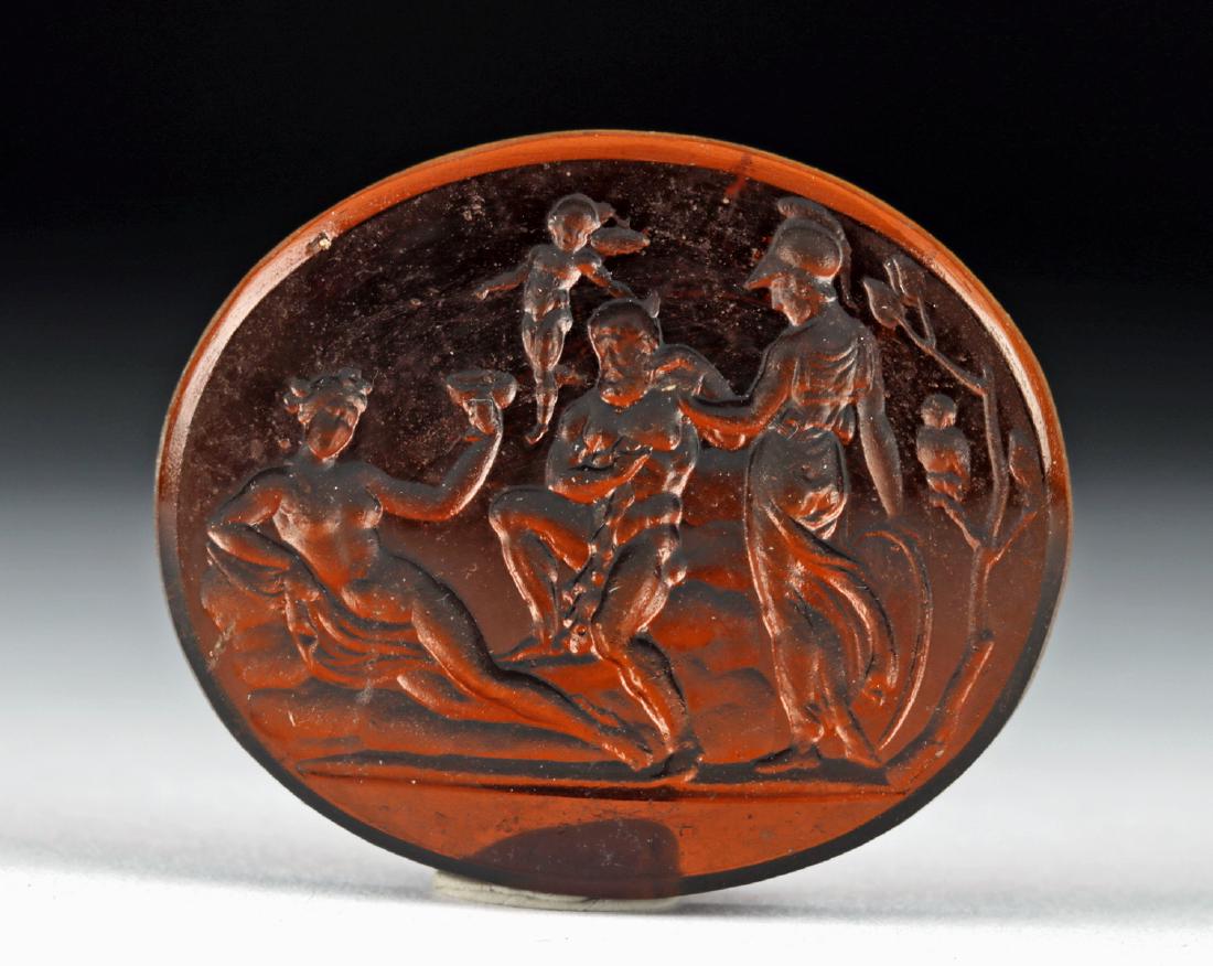18th C. Europe Glass Intaglio - Athena, Aphrodite, Zeus: Northern Europe, Neoclassical period, ca. 18th to early 19th century CE. A charming translucent russet glass intaglio depicting, from left to right, Aphrodite, lounging sensually; Zeus, muscular and p