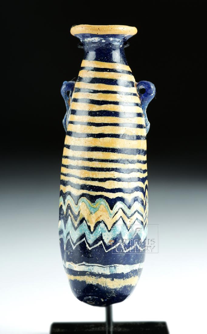Superb Greek Core Form Glass Alabastron: Ancient Greece, ca. 2nd to 1st century BCE. A striking core-formed glass alabastron, so named because many vessels that assumed this form were made of alabaster. The vessel presents a sophisticated ov