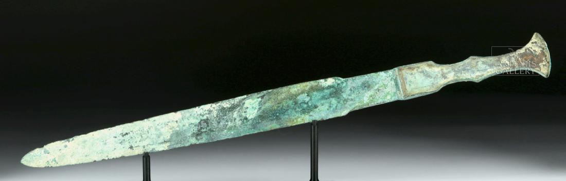 Fine Luristan Bronze Short Sword: Ancient Near East, northwestern Iran, Luristan, ca. 1000 to 600 BCE. A fine bronze short sword cast via the lost wax (cire perdue) process. The weapon has a long blade with a wide midrib along both si