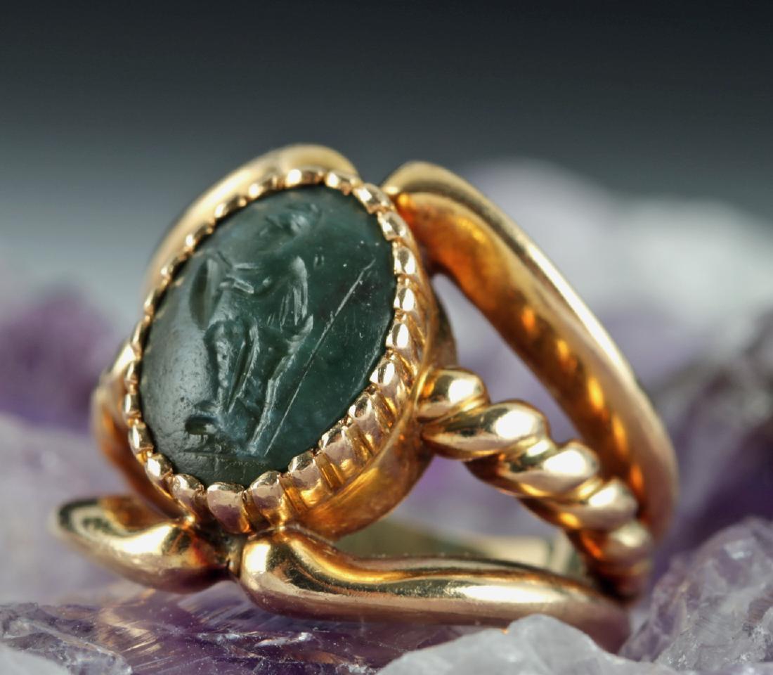 Roman Jasper Intaglio in Modern 16K Gold Ring: Roman, Imperial period, ca. 1st to 3rd century CE. A beautiful ovoid dark green jasper intaglio set into a modern 16 karat gold ring. The intaglio features a soldier, his plumed helmet, tunic, and shi