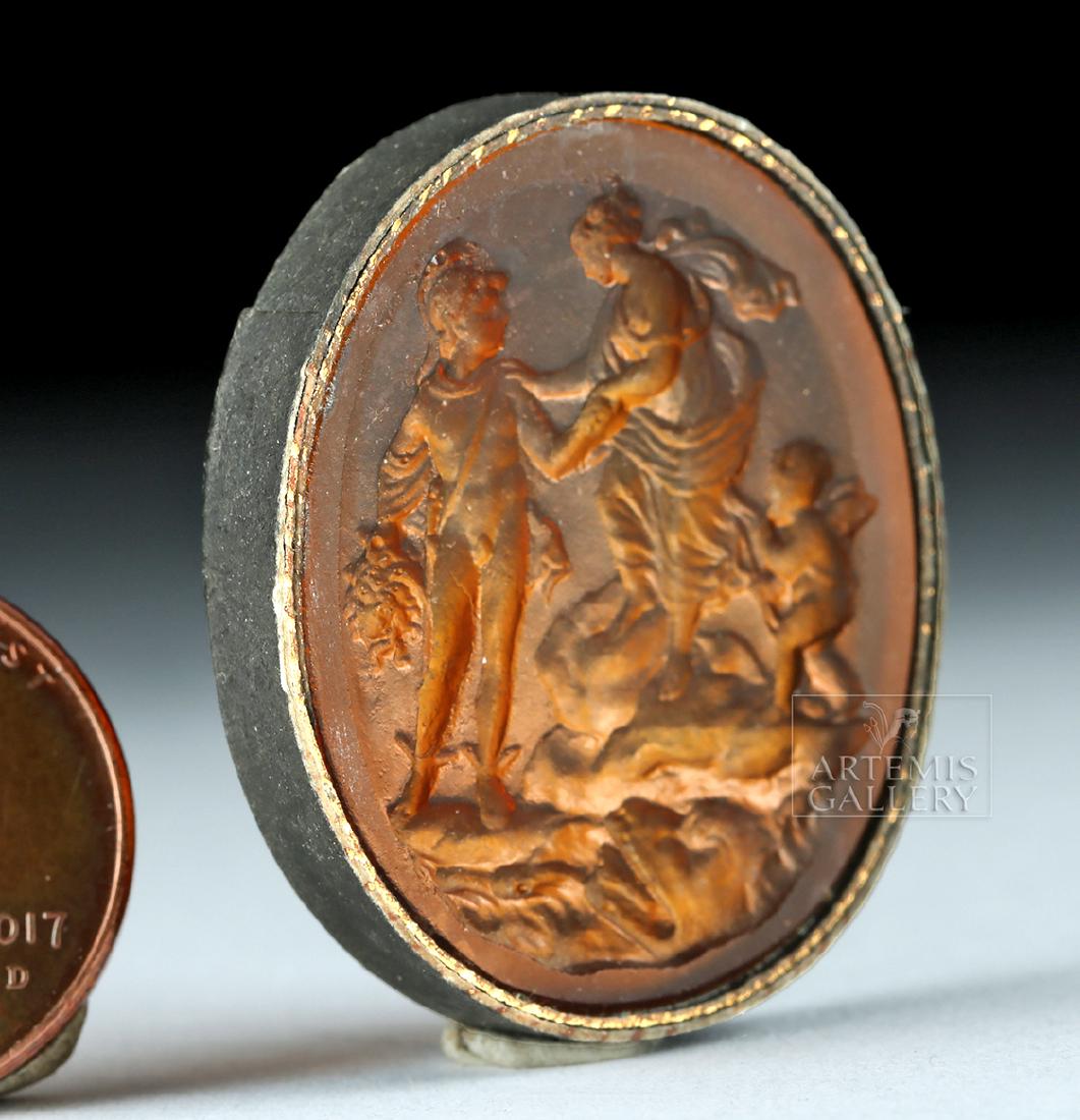 Neoclassical Glass Intaglio - Perseus: Northern Europe, Neoclassical period, ca. 18th to 19th century CE. An attractive amber-hued glass intaglio depicting what appears to be Perseus holding Medusa's head, Aphrodite and Cupid to the right,