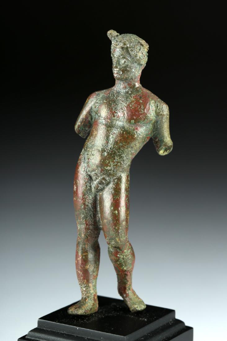 Roman Bronze Statuette of Striding Nude Male: Roman, Imperial period, ca. 1st to 3rd century CE. A handsome cast bronze statuette of a man, shown in a dynamic pose, striding forward, his body portrayed as sensual and nude, the ideal of athletic m