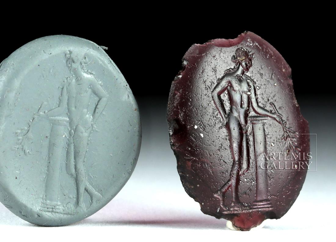 Roman Glass Seal / Intaglio - Nude Male Athlete: Roman, Imperial Period, ca. 1st to 3rd century CE. A translucent glass intaglio of purple hues and marvelous translucency - depicting a nude, male athlete standing with the left leg bent at the knee a