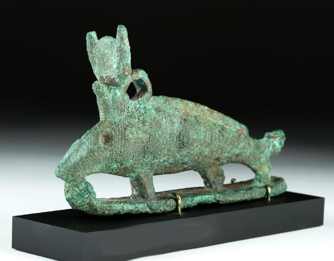 Egyptian Bronze Oxyrhynchus Fish Amulet: Ancient Egypt, Late Period to Ptolemaic, 712 to 30 BCE. A heavy cast-bronze figure of an oxyrhynchus fish wearing on its back a crown with horns, disc, and uraeus. The sides were incised with fine lin